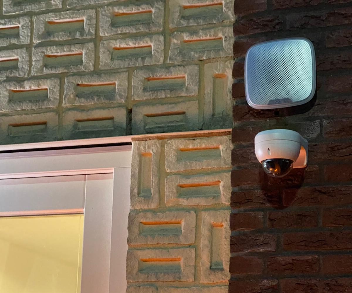 ajaxsirene boven een witte dome camera hangend aan muur